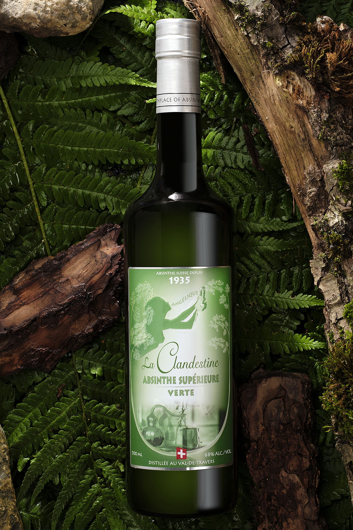 Bouteille d’absinthe verte La Gandestine posée sur des feuillages et bois, label vert vintage et bouchon argenté, ambiance forestière. Comment se procurer de l'absinthe authentique.